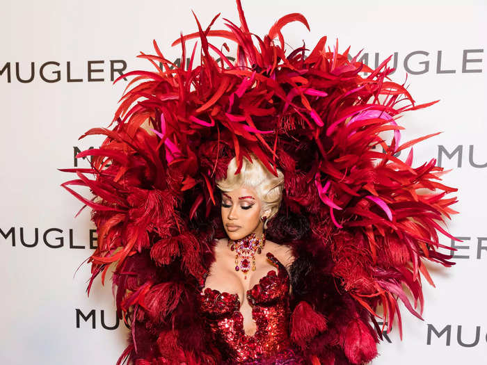 Ever the fan of Mugler, the "WAP" singer attended a Paris exhibition celebrating the designer in a stunning red sequin gown adorned with a huge feather shoulder piece.