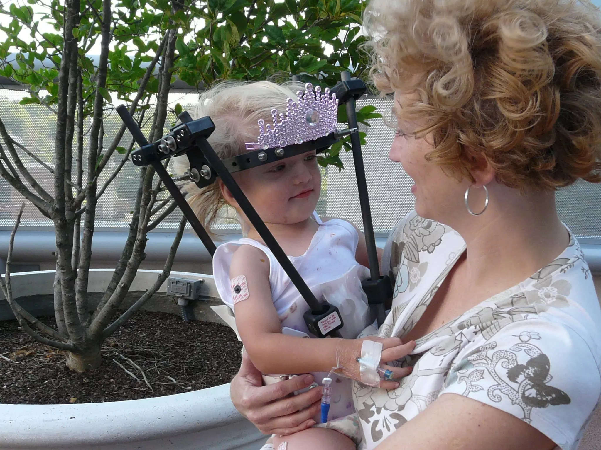 Ava Coulter as a toddler wearing her halo brace. She is being carried by her mother, Tammy Coulter