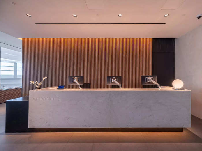 Welcoming customers inside the Club is a large reception area with a check-in desk and a beautiful wood backdrop.