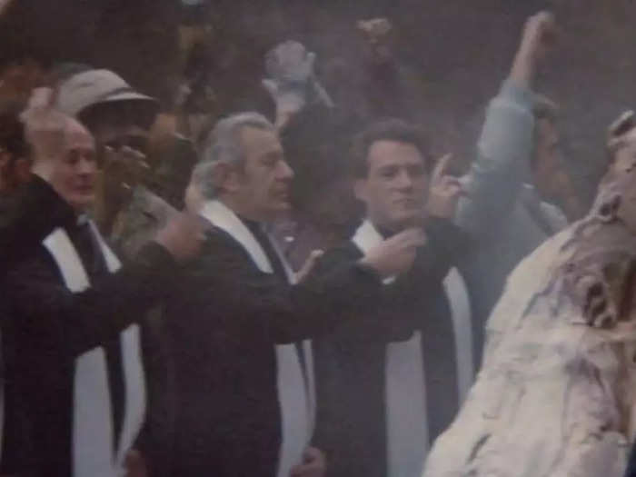 A group of priests blesses a piece of the Stay Puft Marshmallow Man.