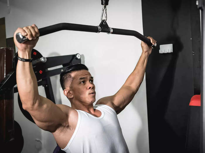 The lat pulldown machine helps sculpt a strong, muscular back.