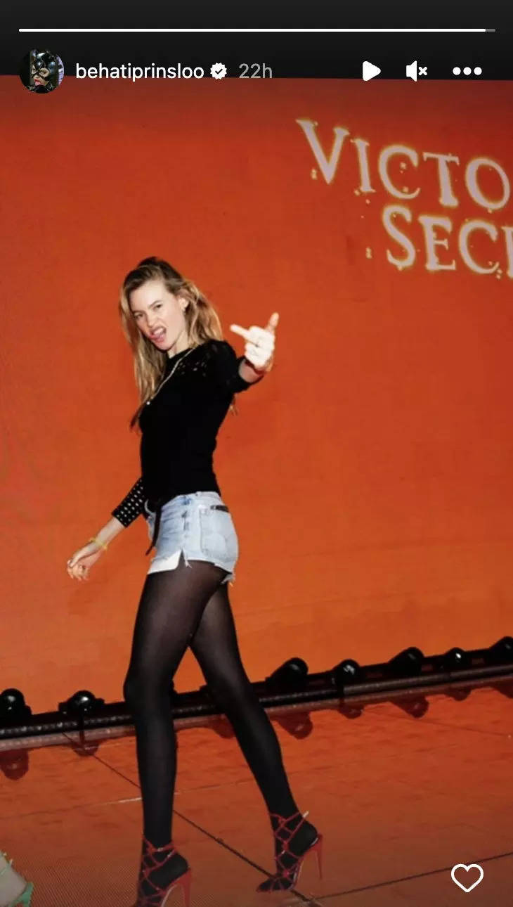 Screenshot of Behati Prinsloo Instagram story: The model holds up her middle finger and tongue at the camera in front of a red backdrop