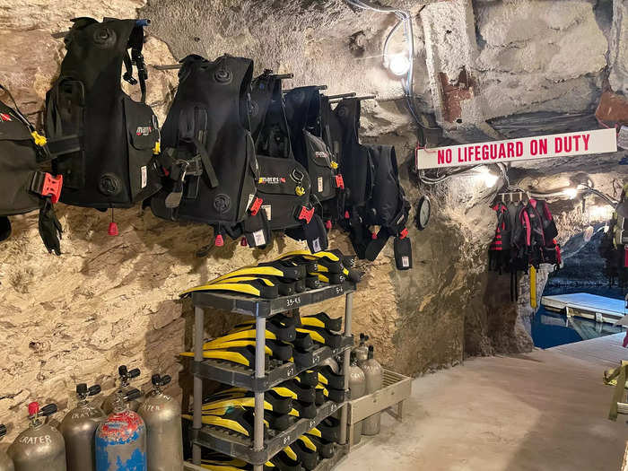 I stepped into a tight hallway and immediately noticed a wet rock smell. Tiny changing rooms filled one wall. On the other side were rows of life jackets, buoyancy control devices, tanks, and snorkels.