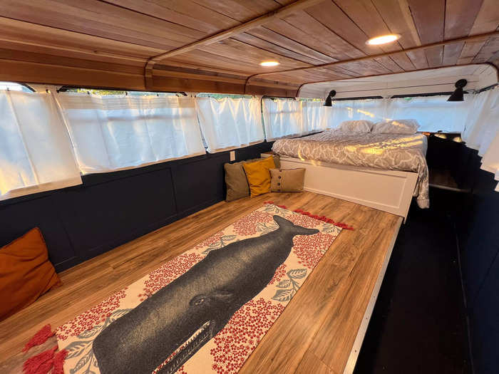 The sleeping area on the second floor of the converted bus features a queen-sized bed.