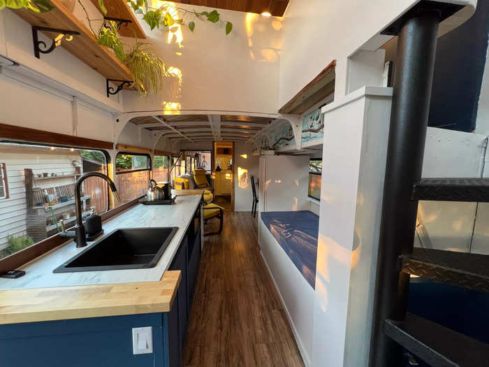 Upon entering the completed bus, a hallway opens up to a kitchen on the left and a reading nook on the right.