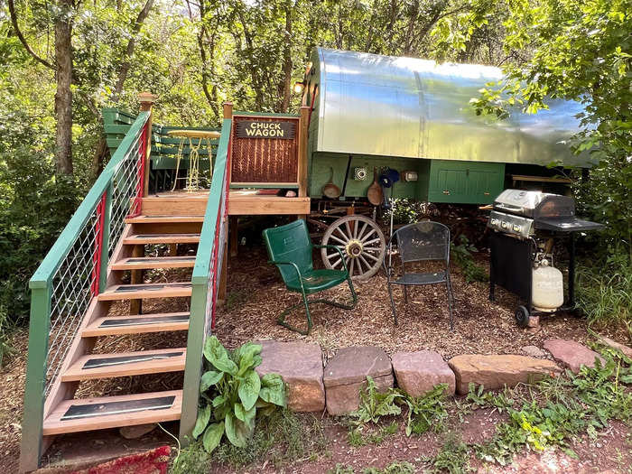 My kelly green wagon with a curved metal roof had wooden steps that led up to a little porch with built-in corner benches and a lemon-yellow metal table. There were also rustic metal chairs, a gas grill, and cooking implements on display.