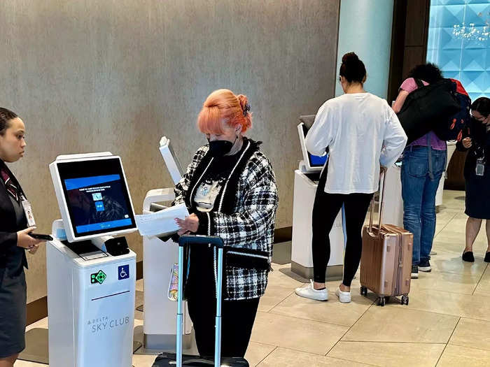 Travelers check-in at five self-service kiosks in the lower Sky Club lobby…