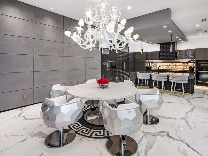 The dining area is located by the open kitchen and comes with a chandelier that