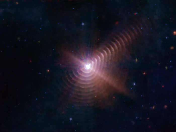 Cosmic dust in the sky created a ripple that looks like tree rings, visible around Wolf-Rayet 140, a binary star system.