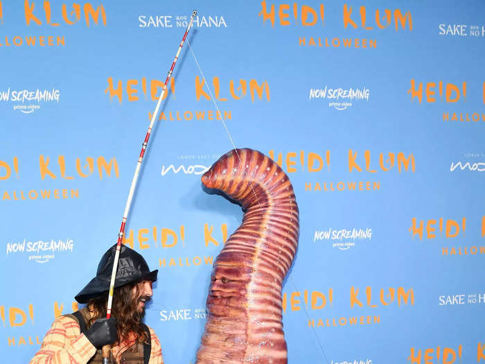 Heidi Klum dressed as a giant worm attached to a fishing pole that was carried by her husband, Tom Kaulitz, who went as a fisherman.