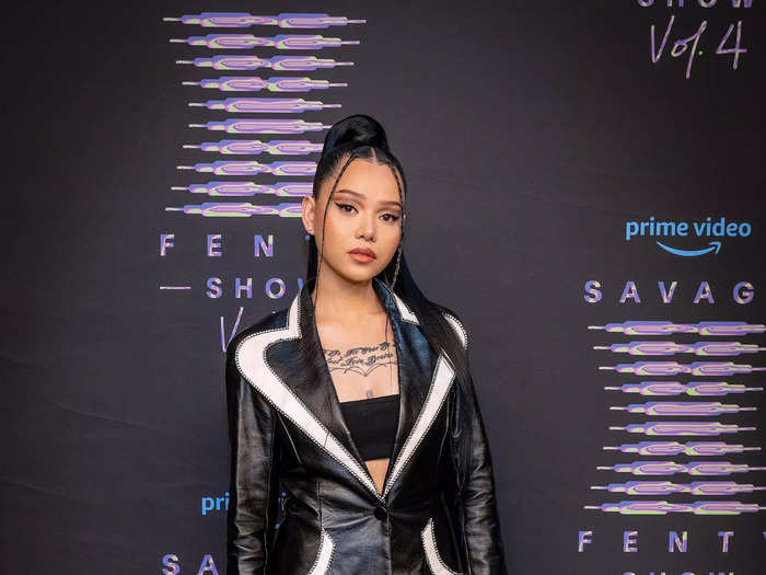 Bella Poarch turned a black-and-white jacket into a dress, pairing it with a black bralette and knee-high boots.