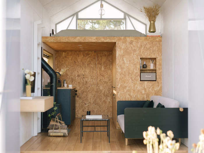 The completed cabin has a rectangular layout, with a sleeping area in the loft that can be accessed with a ladder.