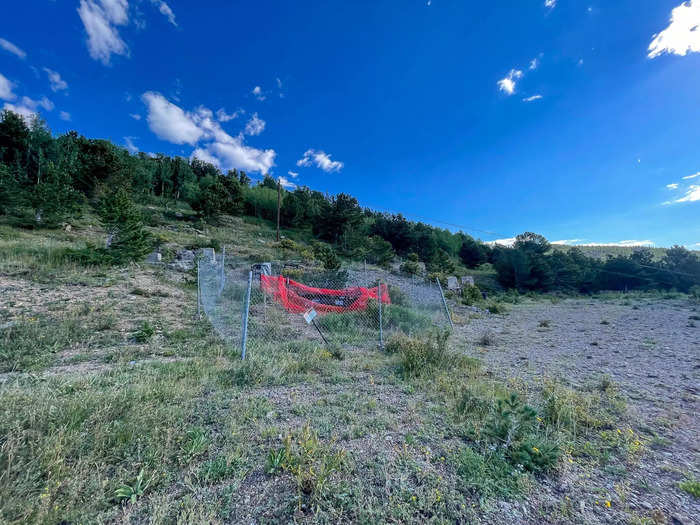 I walked along the road and spotted bright orange fencing and "KEEP OUT" signs cautioning curious explorers to stay away. It was an entrance to the old mine.