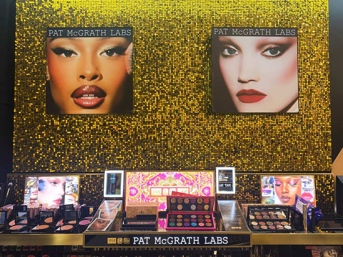 A sparkly golden wall displayed Pat McGrath eyeshadow palettes that were priced between $62 and $128.