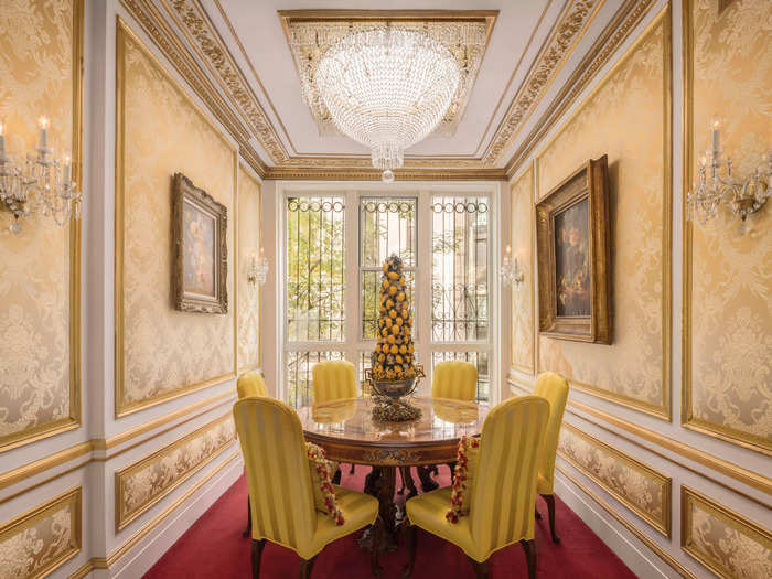 One of the dining rooms boasts elaborate ornamental wallpaper and a crystal chandelier.