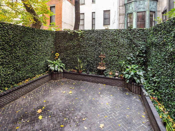 An outdoor garden for the more than 8,700-square-foot home includes tall hedges.