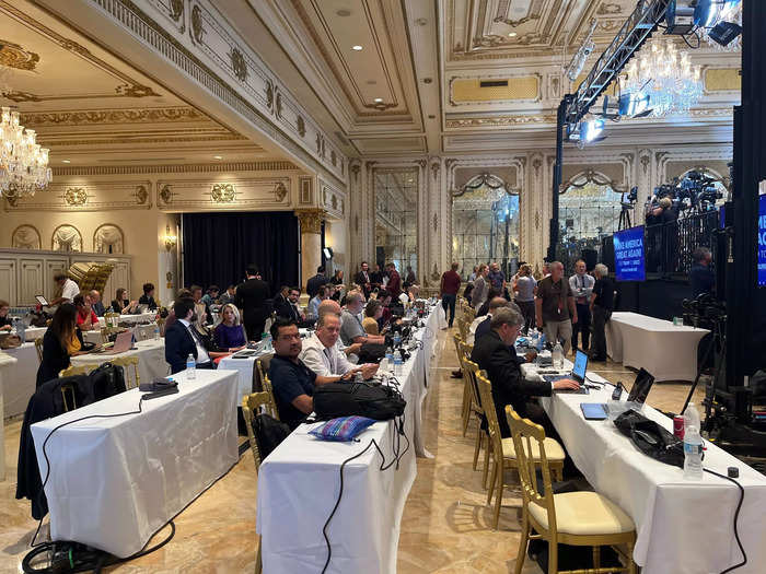 Meanwhile, members of the press sat in the back, with risers dividing the room between media and guests.