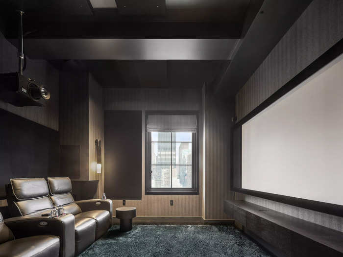 One of the bedrooms has been converted into a home theater with wool Holland & Sherry upholstered walls and four movie theater-style reclining chairs.