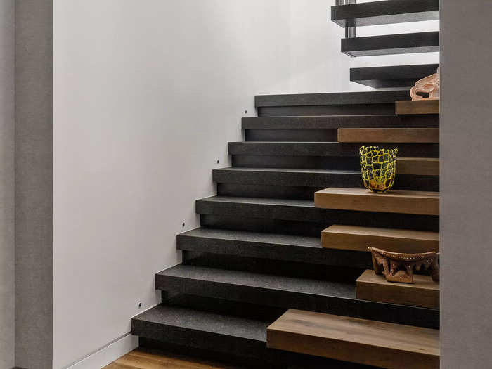 The main entry to the apartment has a floating staircase that leads to the living space above.