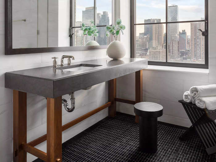 The penthouse has three and a half bathrooms, which feature large windows and black floor tiling.