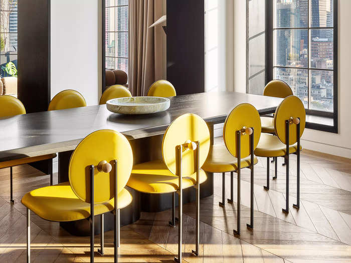 The stylish dining area that can comfortably seat 12 is complete with modern light fixtures and French oak flooring that extends throughout the apartment.