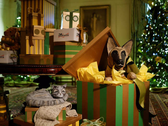 Renderings of Commander and Willow are shown enjoying holiday gifts in the Vermeil Room.