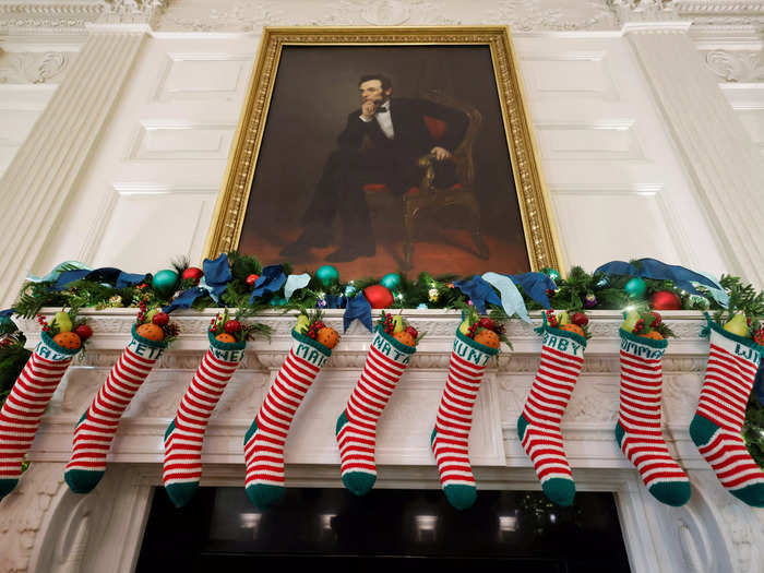 Biden family stockings hang from a mantel in the State Dining Room — including one for Naomi Biden