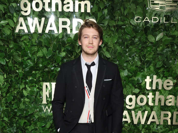 "Conversations with Friends" star Joe Alwyn walked the carpet in a suit and tie, with a cream cardigan underneath his jacket.