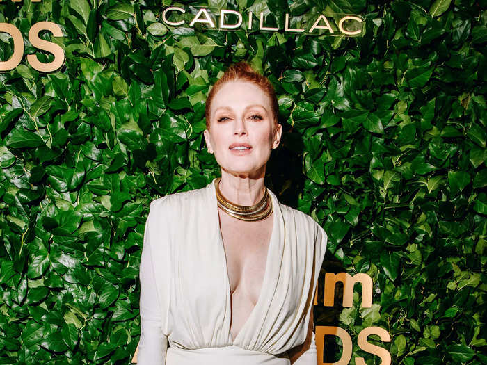 Julianne Moore wore a cream dress with a plunging neckline and accessorized with a gold necklace, bracelets, and a matching clutch bag.