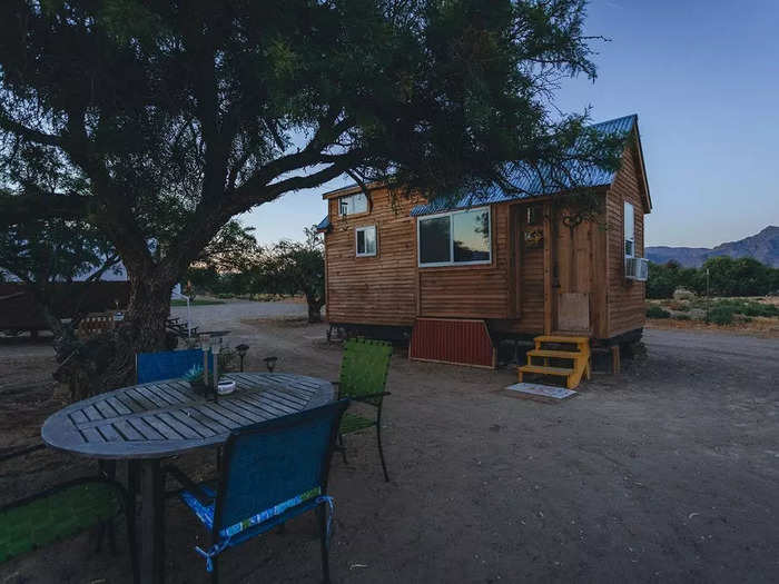 The house has a small, two-person seating area under a Mesquite tree.