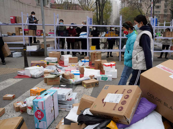 Residents pick up their delivery orders outside a community in Beijing.