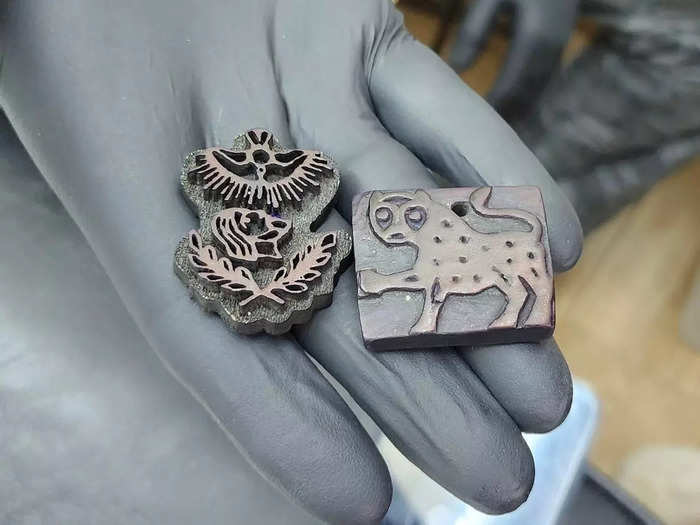 Razzouk uses hand-carved stamps that serve as stencils for their tattoos. They then press the stamp into ink and transfer it onto the customer, using it as an outline that they tattoo over with a traditional tattoo gun.