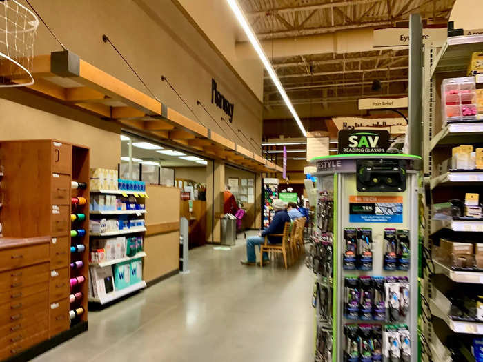 The far end of the store has a pharmacy and aisles of hygiene and beauty products.