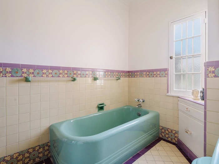 The property has two bathrooms, one of which has a bright-green bathtub and a matching green sink and toilet.