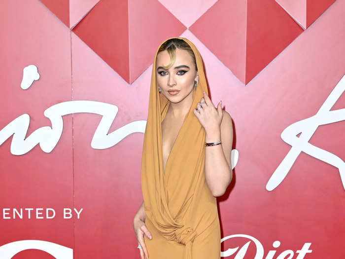 Sabrina Carpenter was one of many stars to wear a hooded gown. Her mustard-yellow dress was also sleeveless and tied at the waist.