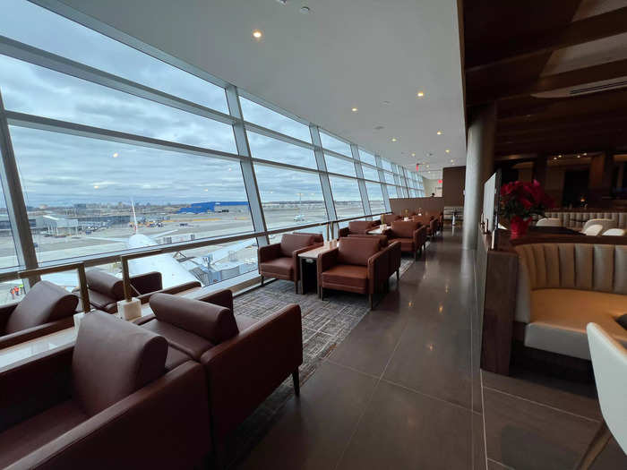 On the left side of the lounge is a long set of floor-to-ceiling windows that overlook the ramp, accompanied by plenty of armchairs.