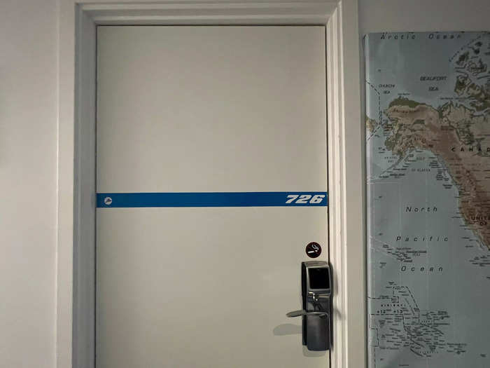 …and doors with the iconic Boeing font leading to most of the 33 rooms that are spread throughout the jet, including hostel-style dorms, standard rooms, and suites.