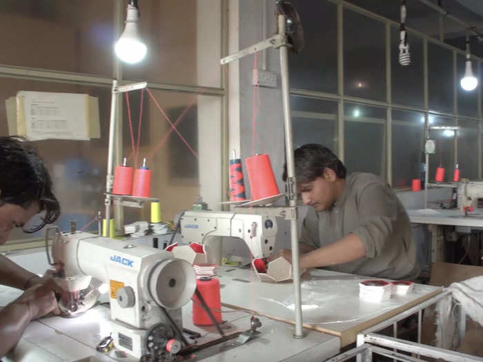 These workers are using sewing machines to put together soccer balls.