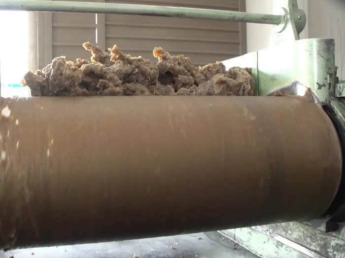 This machine creates sheets out of hot rubber and then cuts them into round shapes.