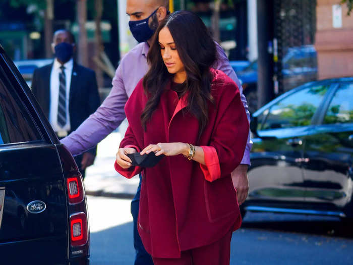 Markle visited schoolchildren in New York in a chic, baggy look maroon suit.