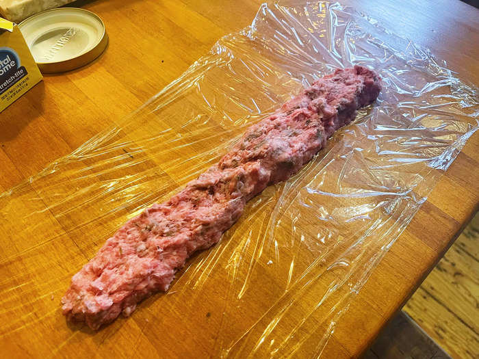 I then split the sausage-meat mixture in half and placed each half on its own piece of plastic wrap.