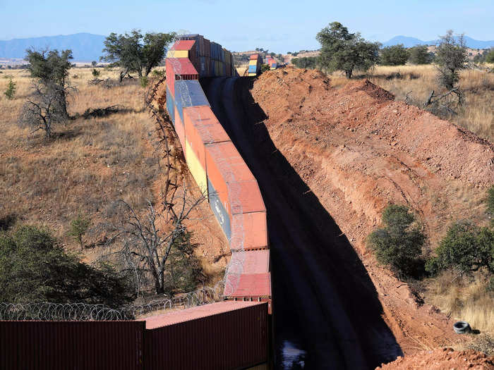 A long row of double-stacked shipping containers provide a new wall between the United States and Mexico in the remote section area of San Rafael Valley, Ariz., Thursday, Dec. 8, 2022.