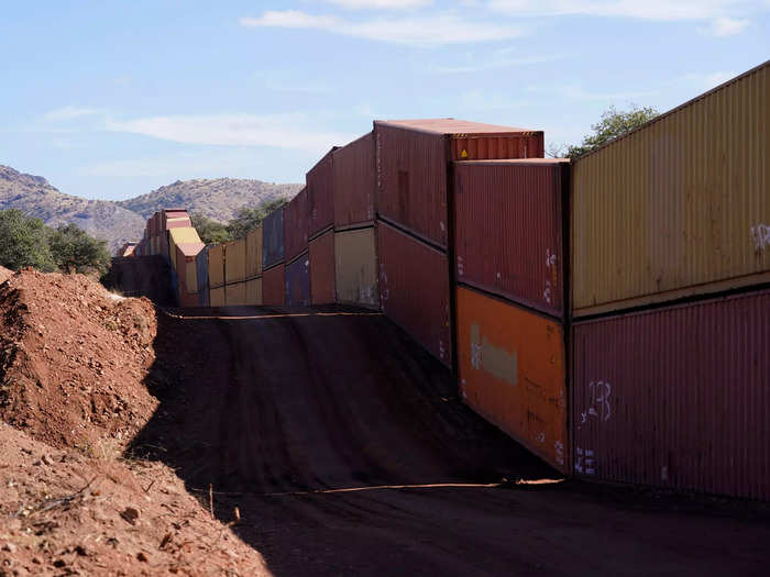 A long row of double-stacked shipping containers provide a new wall between the United States and Mexico in the remote section area of San Rafael Valley, Ariz., Thursday, Dec. 8, 2022.