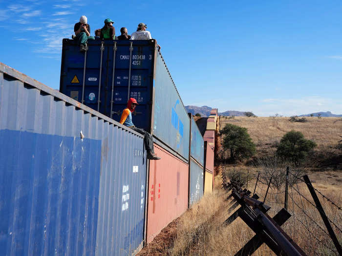 Activists sit on newly installed shipping containers along the border creating a wall between the United States and Mexico in San Rafael Valley, Ariz., Thursday, Dec. 8, 2022.