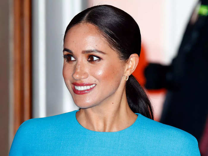 Meghan balanced her brightly colored outfit by keeping her makeup and hair sleek.