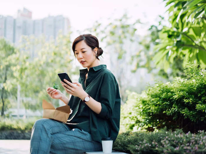 Woman sitting on bench and looking at mobile phone.