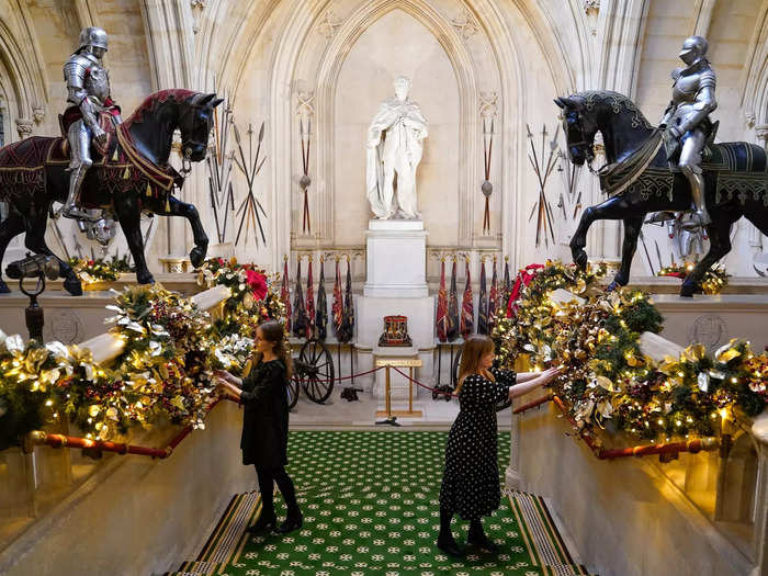 The Grand Staircase at Windsor Castle is covered with festive, twinkling garland.