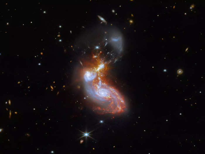 Tendrils of star-forming regions connect the cores of these two merging galaxies and make them much brighter in infrared.