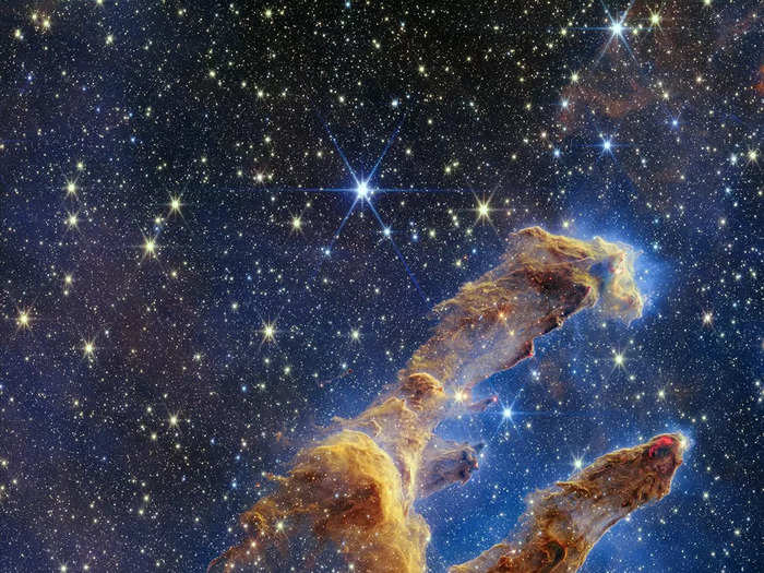 Webb shed new light on the iconic Pillars of Creation — giant clouds of gas and dust that constantly birth new stars. In near-infrared light, thousands of stars burst through, including newborn red stars.