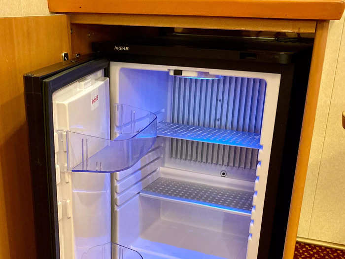 Inside a table, there was a mini fridge that was big enough to store two bottles of wine and a few snacks.